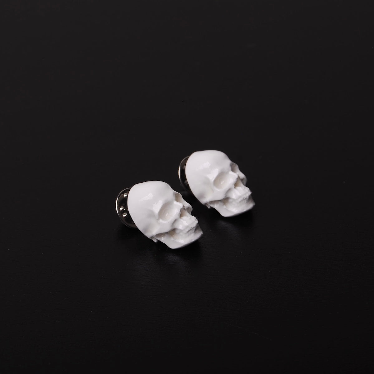 coppia di spillette a forma di teschio bianco, vista 3/4